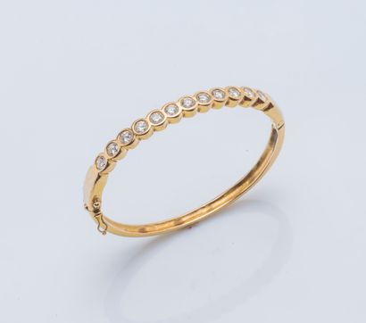 null 18K yellow gold (750 ‰) opening bangle bracelet adorned with a line formed of...