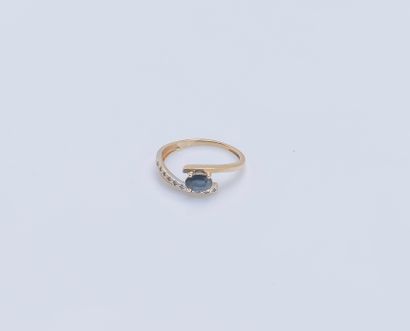 null 18K (750 ‰) yellow gold band ring set with an oval sapphire and a line of 8/8...