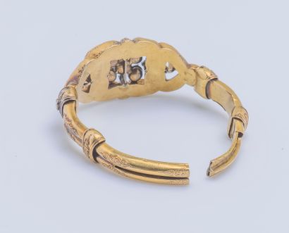  Bracelet jonc articulé en or jaune 18 carats (750 ‰) ciselé, le motif central serti...
