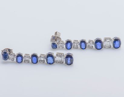 null Pair of 18K (750 ‰) white gold earrings adorned with five falling oval sapphires...