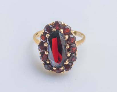 null Flower ring in yellow gold 18 carats (750 thousandths) set with an oval garnet...