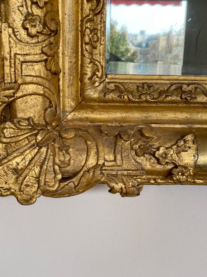 null 
Miroir en bois doré à large fronton orné de deux figures masculines retenant...