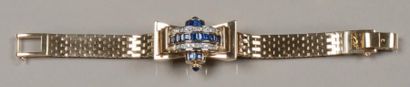 1940 Bracelet montre de dame en or jaune à capot serti d'une ligne de saphirs calibrés...