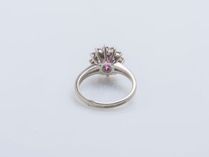null 18K (750 ‰) white gold flower ring set with an oval pink sapphire surrounded...