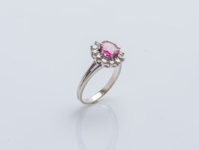 null 18K (750 ‰) white gold flower ring set with an oval pink sapphire surrounded...