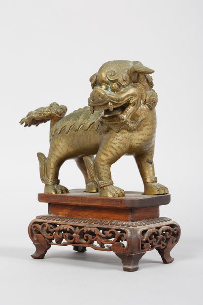 null Chine
Chien Fô en bronze doré sur un socle en bois ajouré 
H. 16 cm
