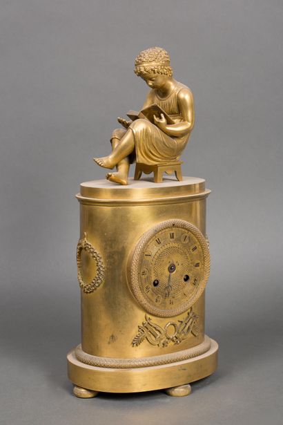 null Gilt bronze clock decorated with lyres and plamettes, surmounted by a young...