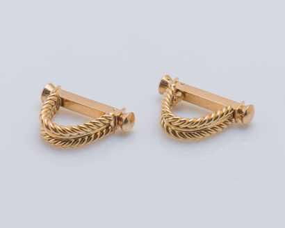 null Pair of 18K (750 ‰) yellow gold cufflinks with stirrup shape and twisted decoration....