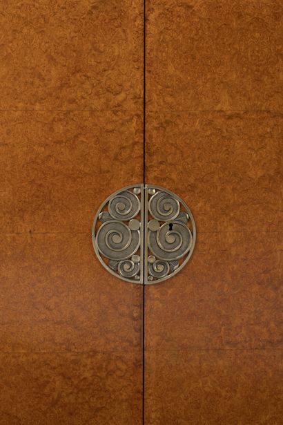 null Burr wood veneer high cabinet, opening with two leaves adorned with an ironwork...