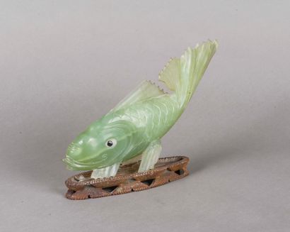 null Chine, XXème siècle 
Carpe en jade sculpté reposant sur un socle en bois sculpté....