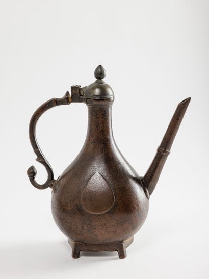 null Verseuse à boire Moghole, en fonte de laiton gravé, XVIIIe siècle. 
H.: 26 cm...