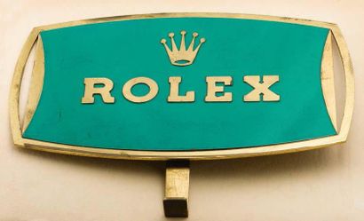 ROLEX (PLAQUE HORLOGÈRE), vers 1960 Plaque de distributeur en métal doré émaillé...