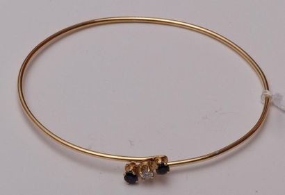 null Bracelet fin rigide en or jaune, le motif central serti d'un saphir et de deux...