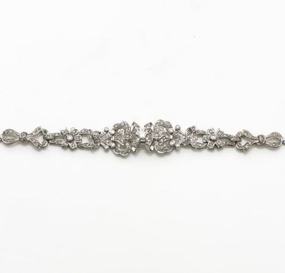 null Bracelet articulé en or gris à décor de noeuds serti de diamants dont un central...