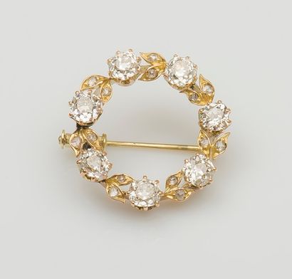 null Broche ronde en or jaune 14 carats (585 millièmes) formant une couronne de fleurs...