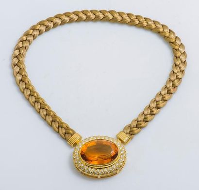  Collier en or jaune 18 carats (750 millièmes) formé d’un lien de tissu tressé retenant...