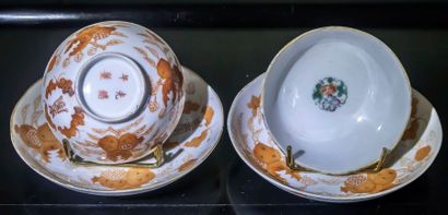 null Paire de tasses et sous-tasses en porcelaine de Chine à décor ocre de végétaux...