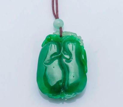 null Collier formé d’un lien de coton soutenant un pendentif en jade sculpté de deux...