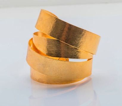 HERVÉ VAN DER STRAETEN Bracelet manchette en métal doré, formant un ruban souple....