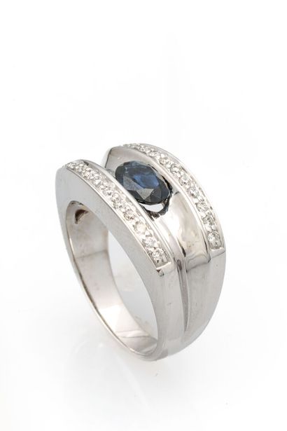 null White gold ring set with an oval-cut sapphire and two lines of diamonds.
Weight:...