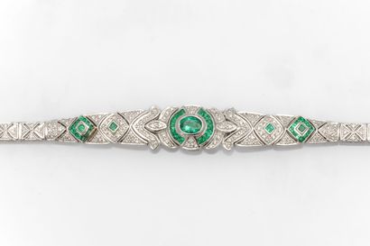 null White gold bracelet adorned with an oval-cut emerald and calibrated emeralds...