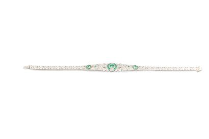 null White gold bracelet adorned with an oval-cut emerald and calibrated emeralds...