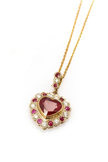 null Heart pendant and chain in two golds set with a treated heart-cut ruby weighing...