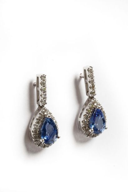 null Pair of 18K white gold ear pendants set with two pear-cut Sapphires totaling...