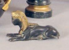null PETIT SPHINX en bronze patiné et doré. XIXe siècle. Long.: 8,5 cm