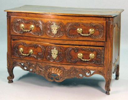 null COMMODE galbée en noyer et sculpté de cartouches et d'agrafes feuillagées, ouvrant...