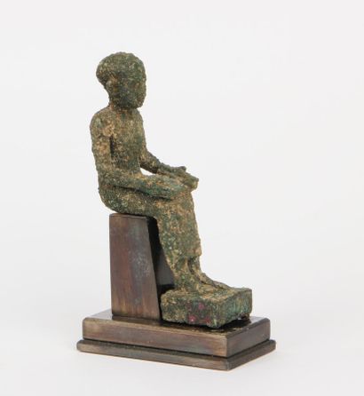null IMHOTEP SEATED, a papyrus scroll on his knees, his feet resting on a quadrangular...