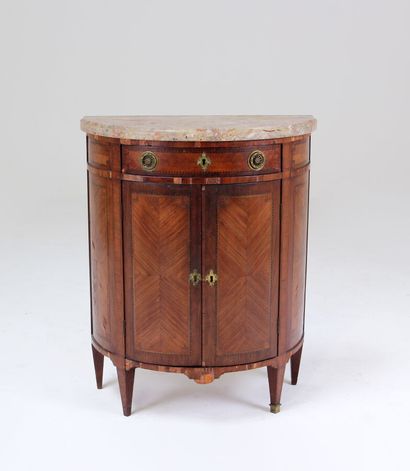 null A half-moon chest of drawers in veneer, inlaid with friezes and framed in tinted...