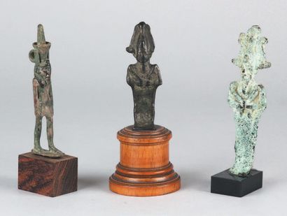 null TROIS DIVINITÉS en bronze: Nefertoum, coiffé de la fleur de lotus, et Osiris,...