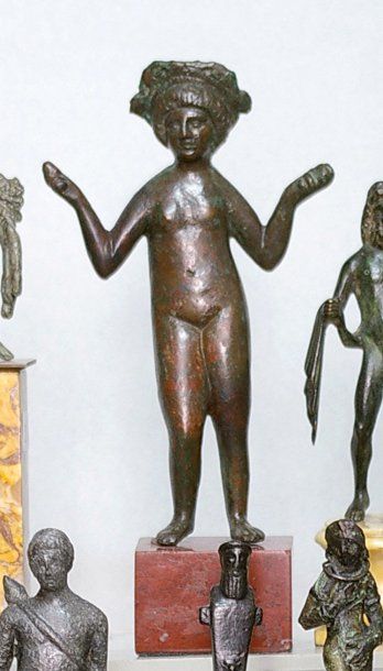 null Vénus en bronze, représentée debout, nue, les bras levés. Chevelure en mèches...