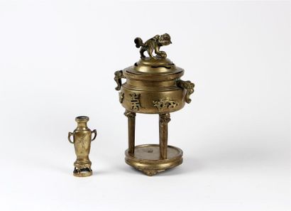 null BRÛLE-PARFUM tripode en bronze, le couvercle orné d'un chien de Fô, les anses...