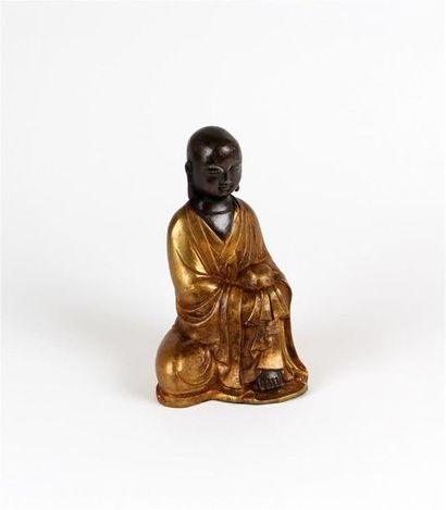 null MOINE tibétain en bronze patiné et doré, il est représenté assis, un genou contre...