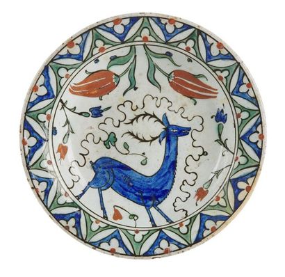 null PLAT d'Iznik en céramique siliceuse à décor peint d'un cerf, tulipes et feuillages...