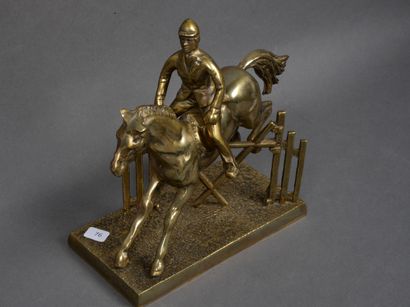 null Sculpture en régule figurant un cavalier et son cheval sautant un obstacle,...