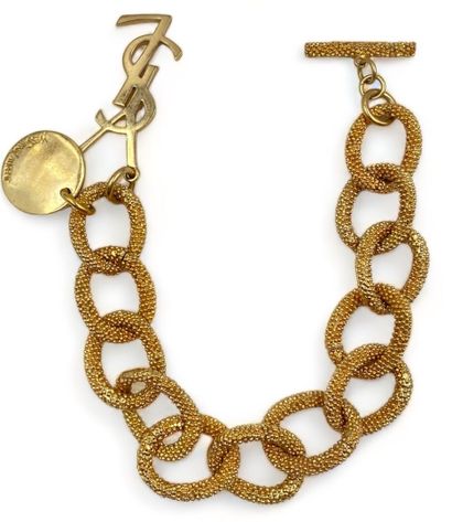 Yves SAINT LAURENT Beaded mesh bracelet
Gilded metal
1 signed circular charm
1 charm...
