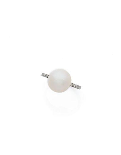 null Platinum 850 ‰ ring centered with an important fine button pearl embellished...