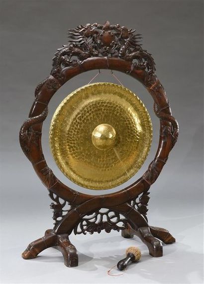 INDOCHINE - Vers 1900 Gong en laiton repoussé et son support en bois sculpté façon...