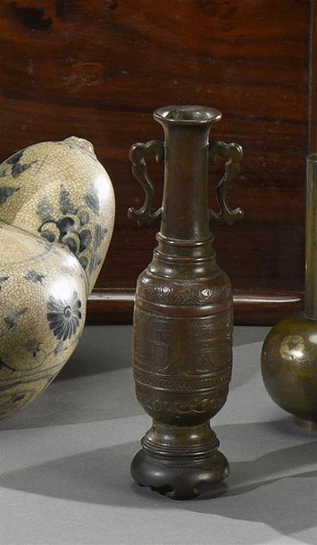CHINE DU SUD - XIXe siècle Haut vase à deux anses en bronze patiné, à décor gravé...