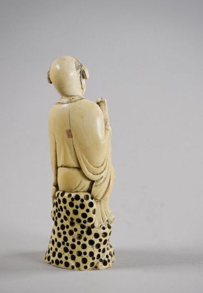 CHINE - Vers 1900 Statuette en ivoire à sujet d'un Karako tenant un panier
Signé...