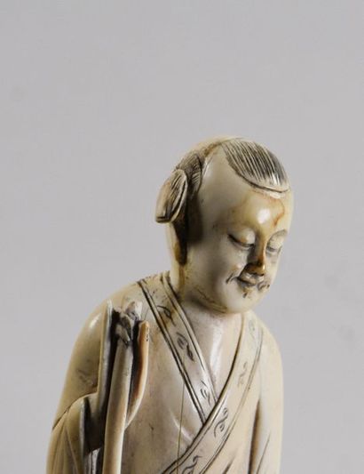CHINE - Vers 1900 Statuette en ivoire à sujet d'un Karako tenant un panier
Signé...