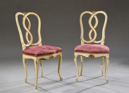 null Paire de chaises en bois relaqué crème à rehauts or, le dossier ajouré et sculpté...