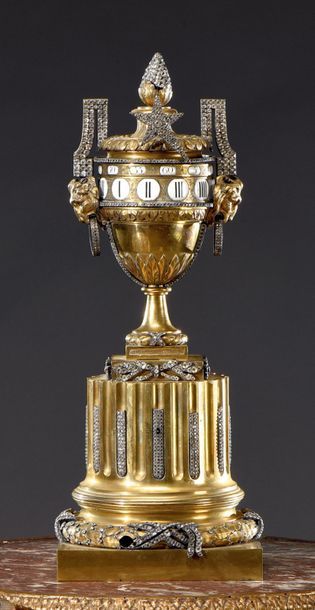 null Gilt bronze clock, in the shape of an urn on a fluted column with a rotating...