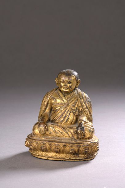 null TIBET - XVIIIe siècle Statuette en bronze doré, lama assis sur un socle en forme...