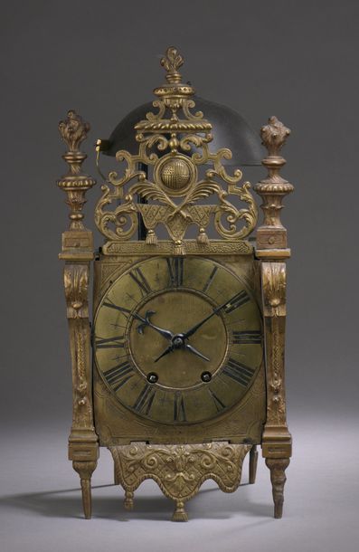 null FITTING CLOCK in brass and sheet metal decorated with draperies, scrolls, coat...
