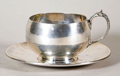 null Tasse et sa sous-tasse en argent uni, la anse à décor de rinceaux feuillagés...