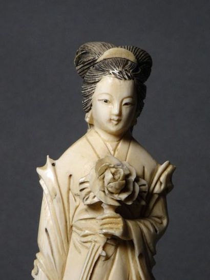 null **CHINE - Vers 1900
Okimono en ivoire à sujet d'une jeune femme au bouquet de...